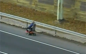 Old Person Takes To Highway on Mobility Scooter
