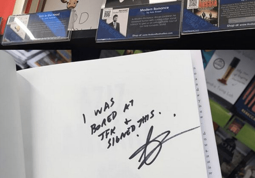When Aziz Ansari Gets Bored At The Airport, He Signs Random Copies Of His Book