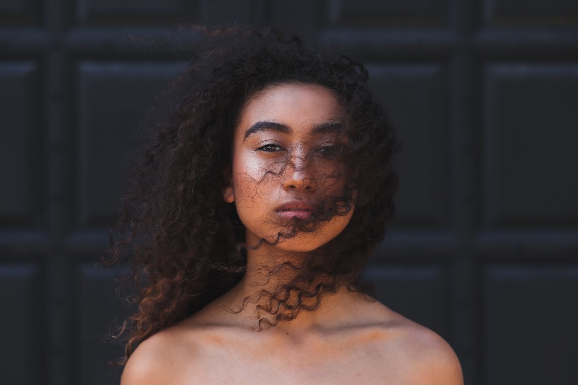 Young woman with curly hair staring at camera