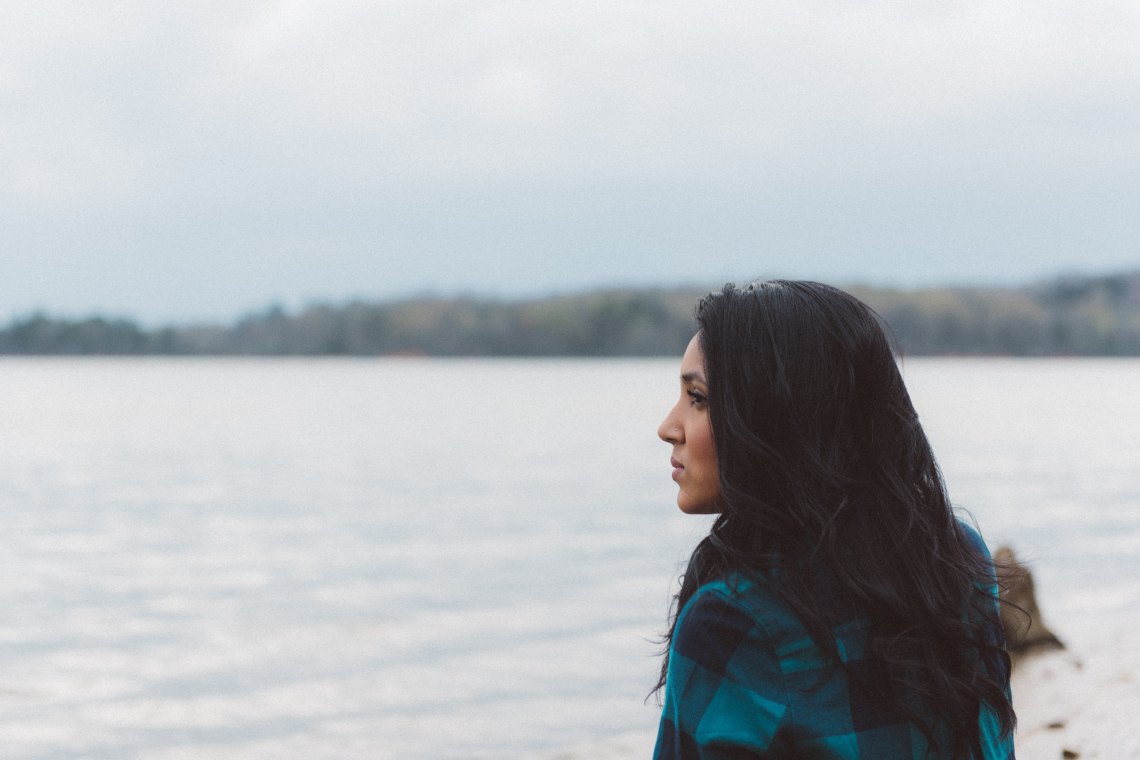 Woman with dark hair looking at ocean