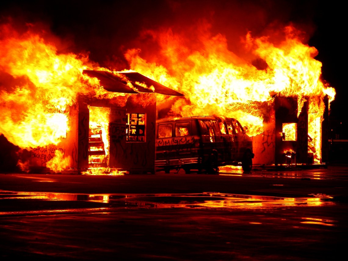 A van is on fire and there is chaos and destruction
