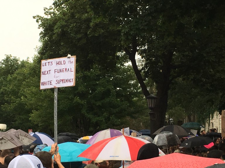 Sign against white supremacy stands out at a rally