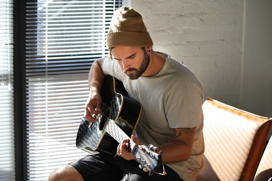 Guy in beanie playing guitar