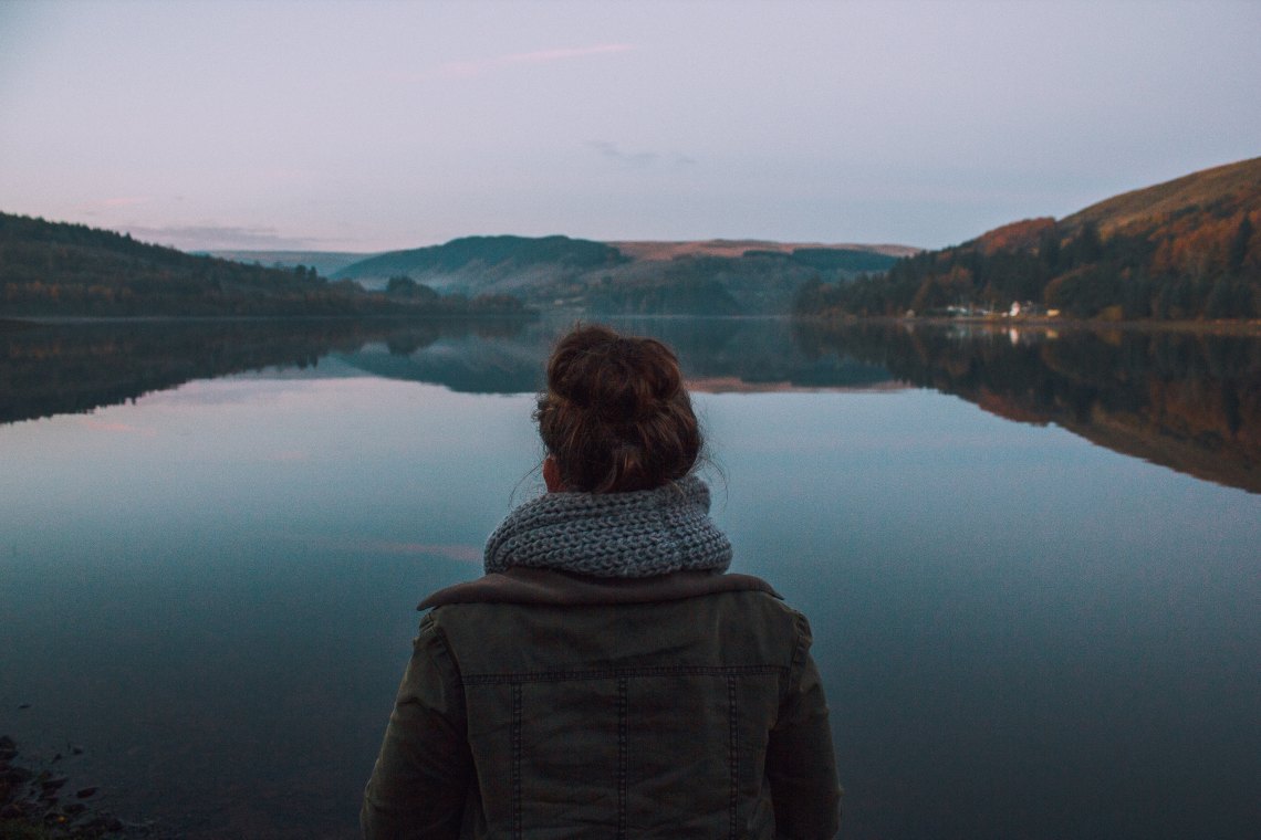 Woman with messy bun staring over mountains