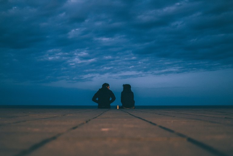Couple sitting in front of dark sky
