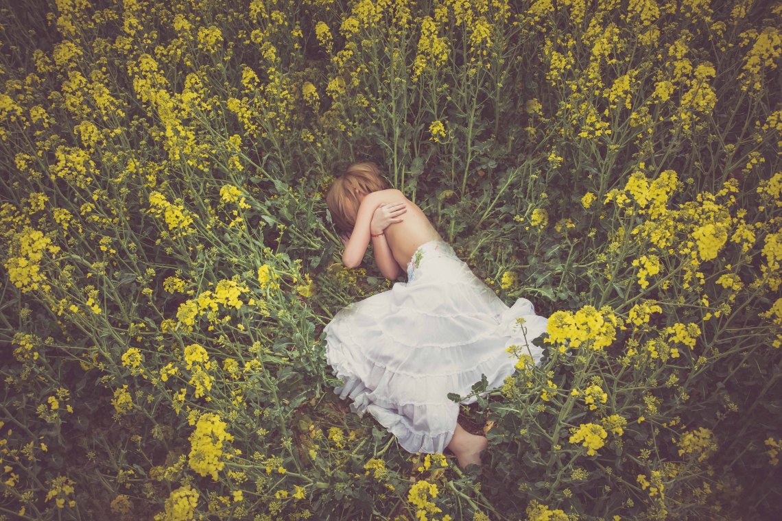 Woman in white skirt laying in field