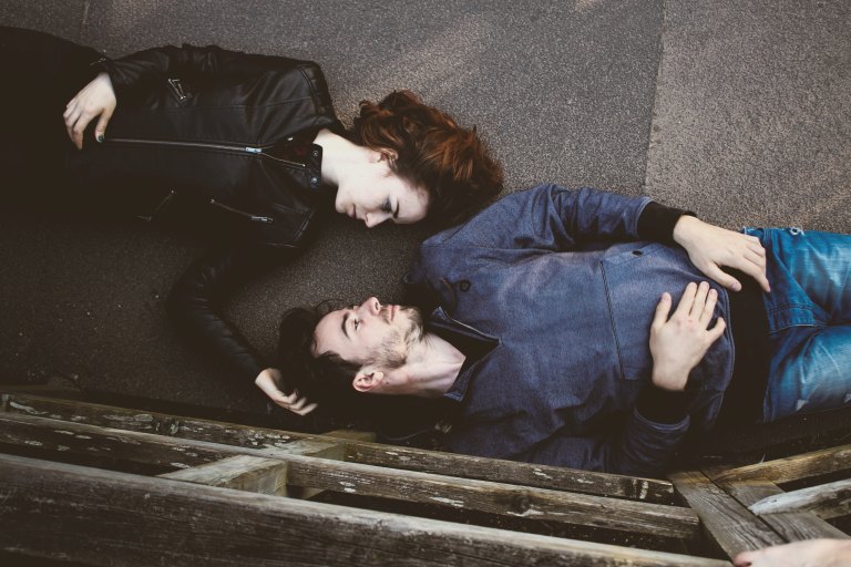 Couple laying on pavement together