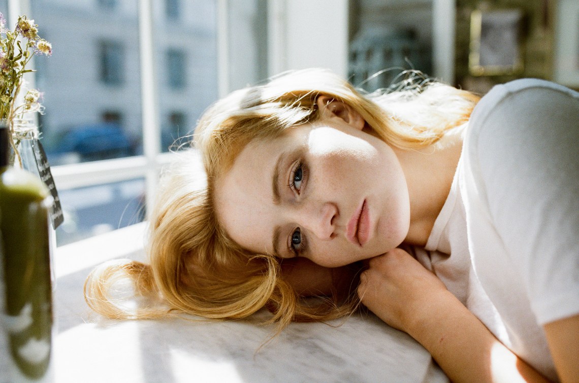 blonde girl resting head on table