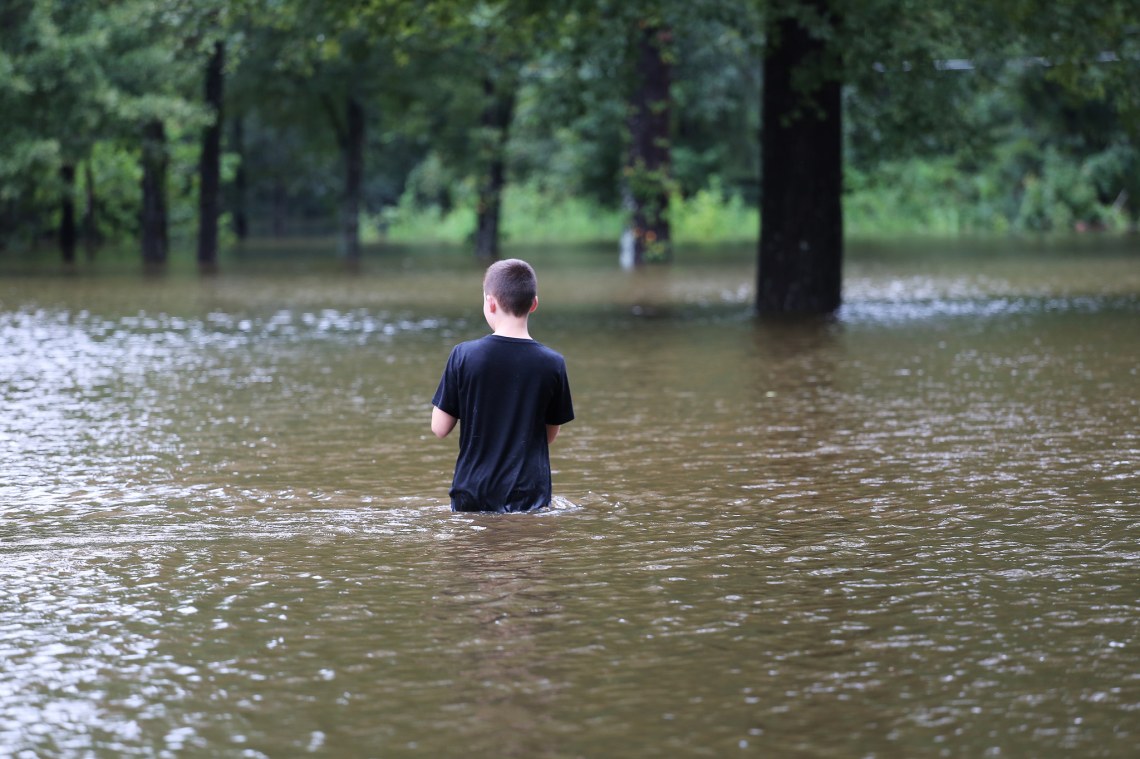 Boy stands in the flood waters during Hurricane Harvey in Texas