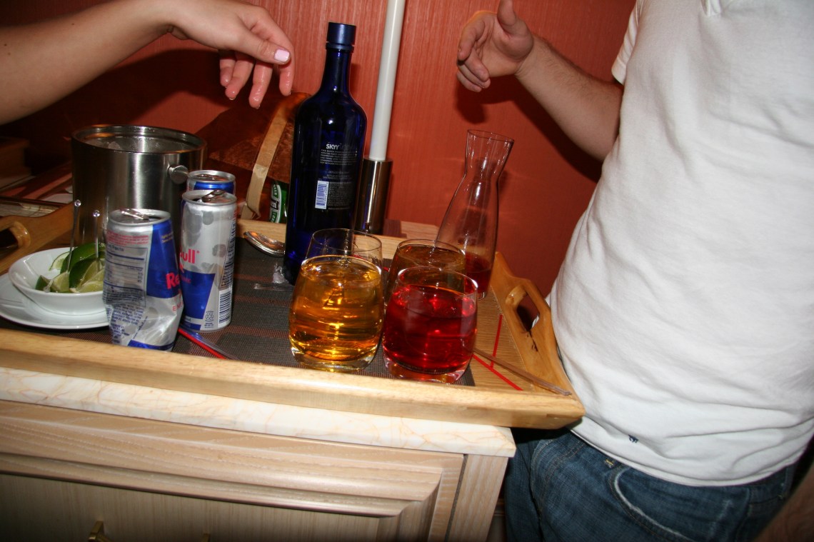 Two friends talk over a multitude of alcoholic beverages and red bull