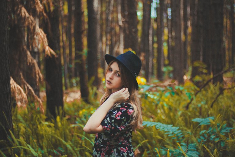 Girl in fedora in woods