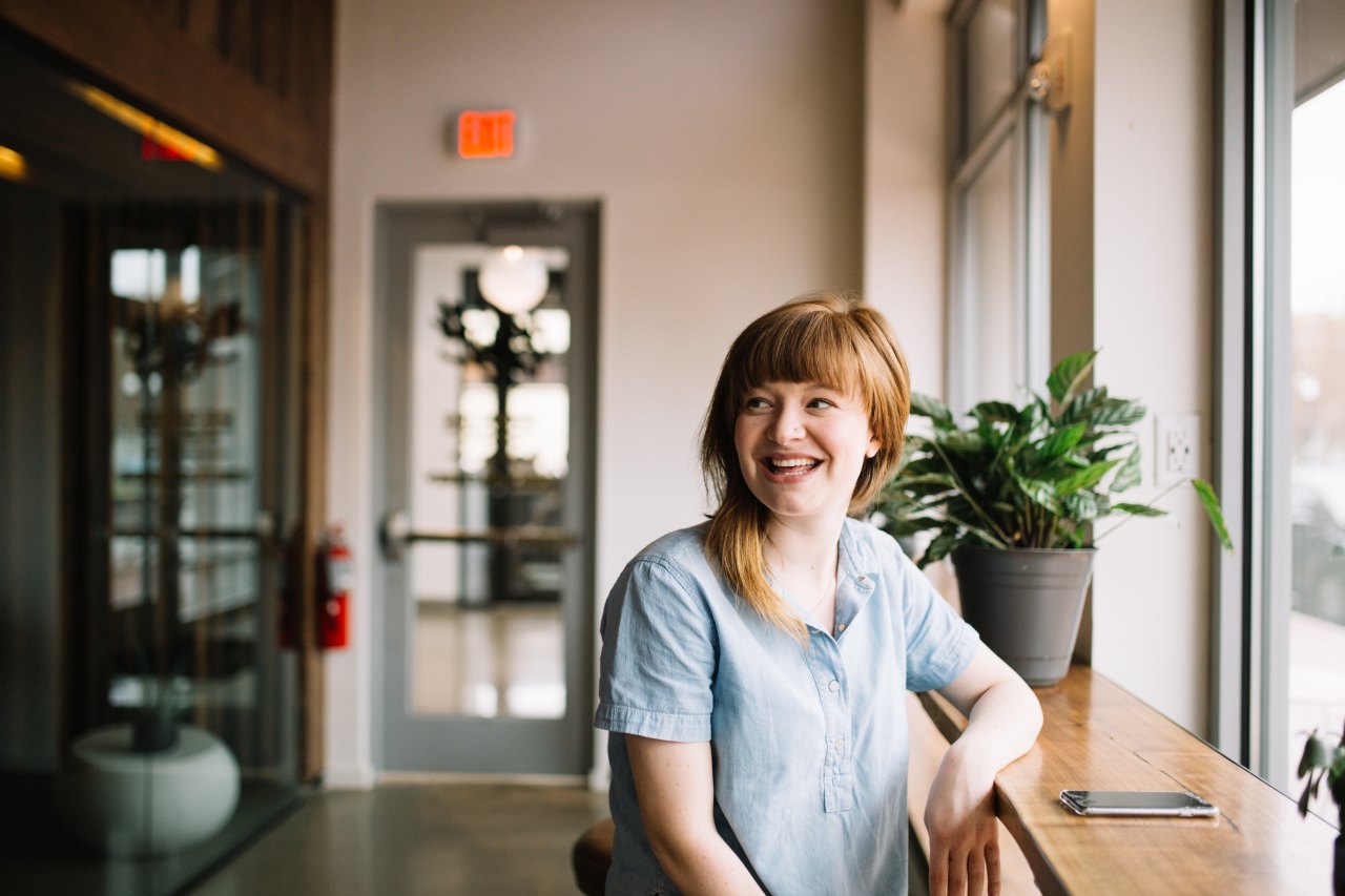 Woman sitting in bright cafe