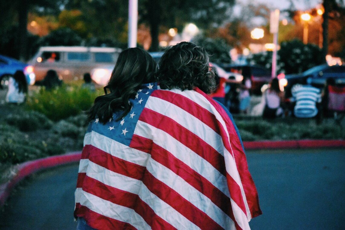 AMERICAN FLAG DRAPED OVER TWO WOMEN