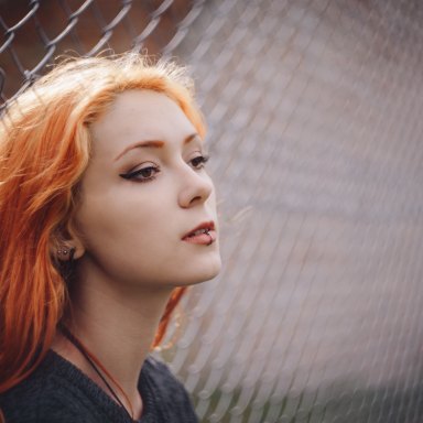 redhead leaning on fence