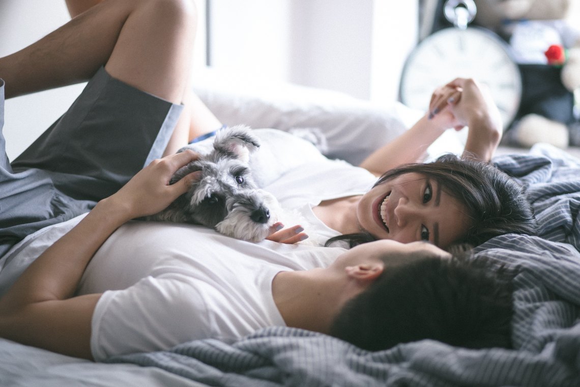 couple laying in bed happy