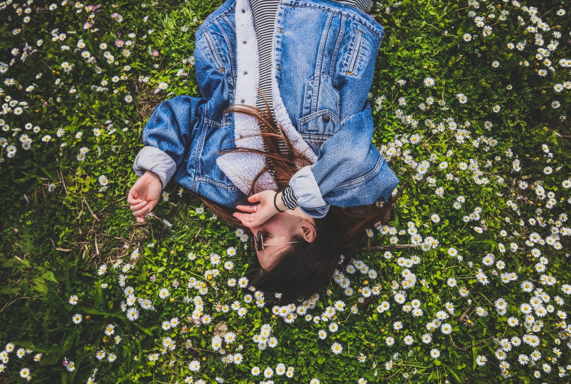 woman laying in daisies