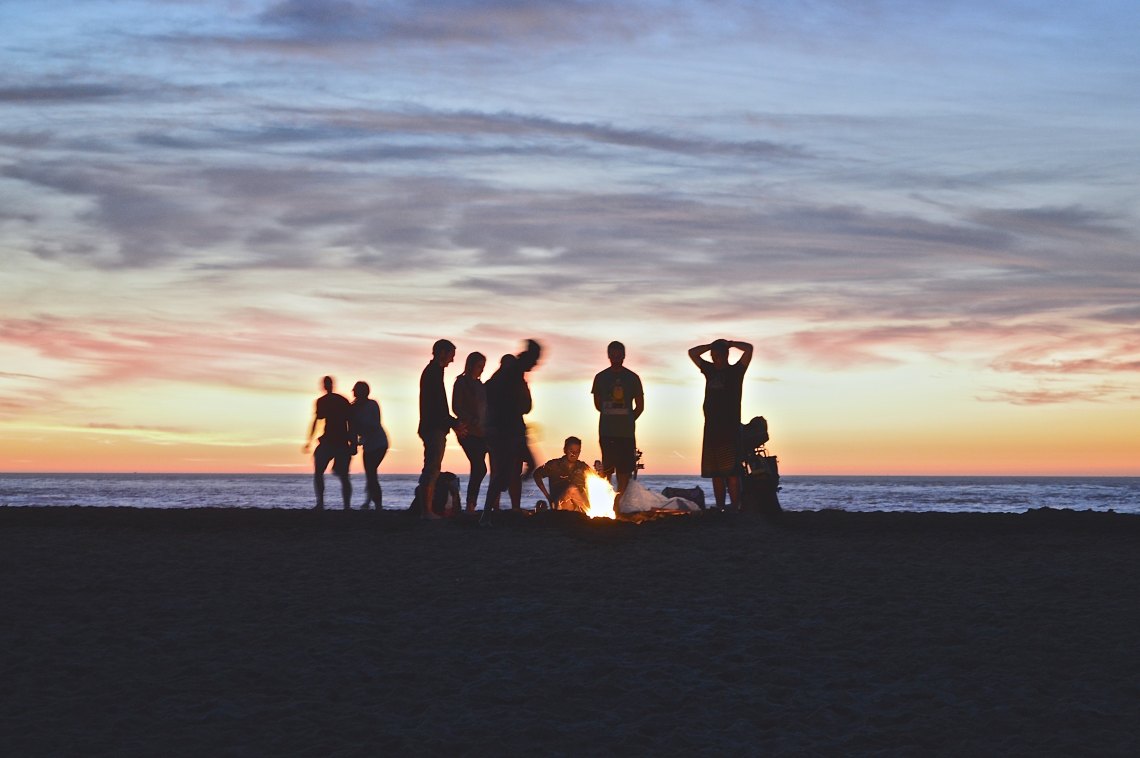 friends on beach at bonfire