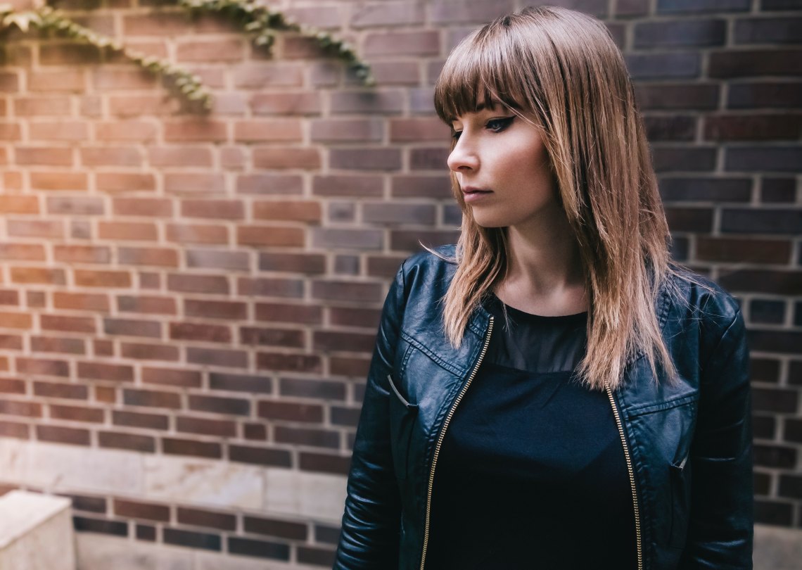 woman standing in front of brick wall