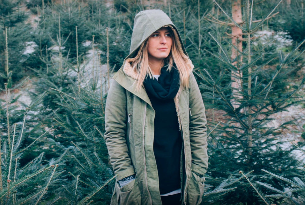 Girl standing amongst fir trees