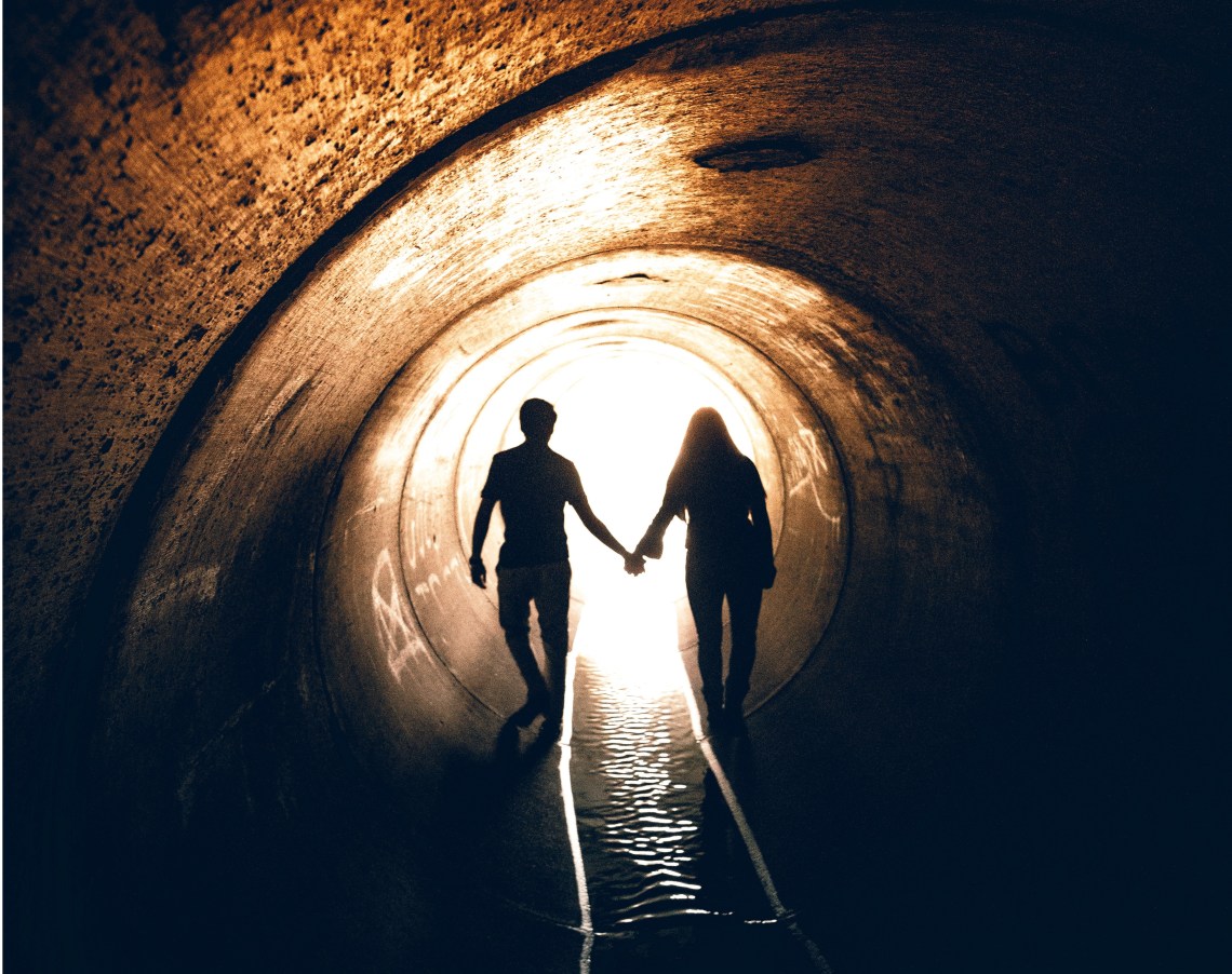 couple walking in tunnel, scared of letting go, letting go, scared to let go