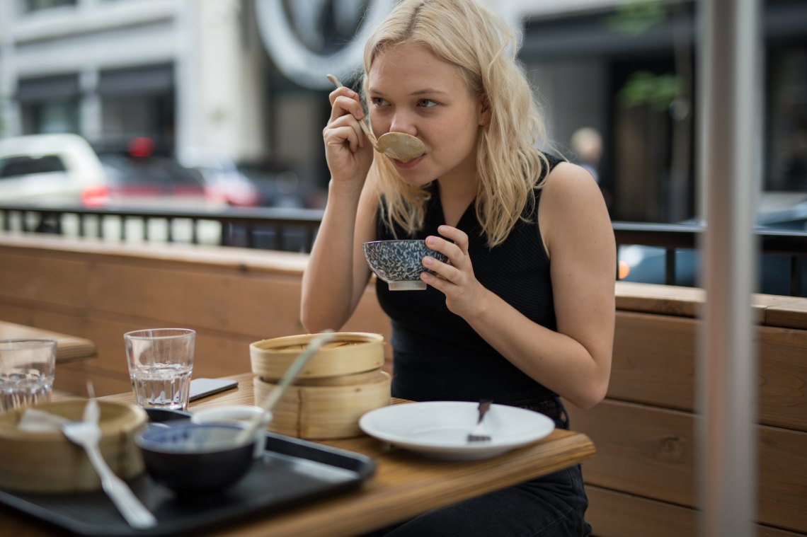 girl at restaurant eating chinese food