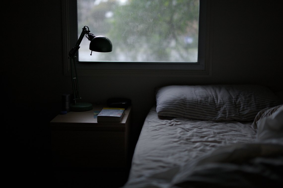 A dark bed in a dark room