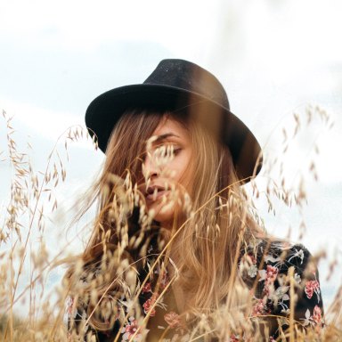 Woman in fedora in field