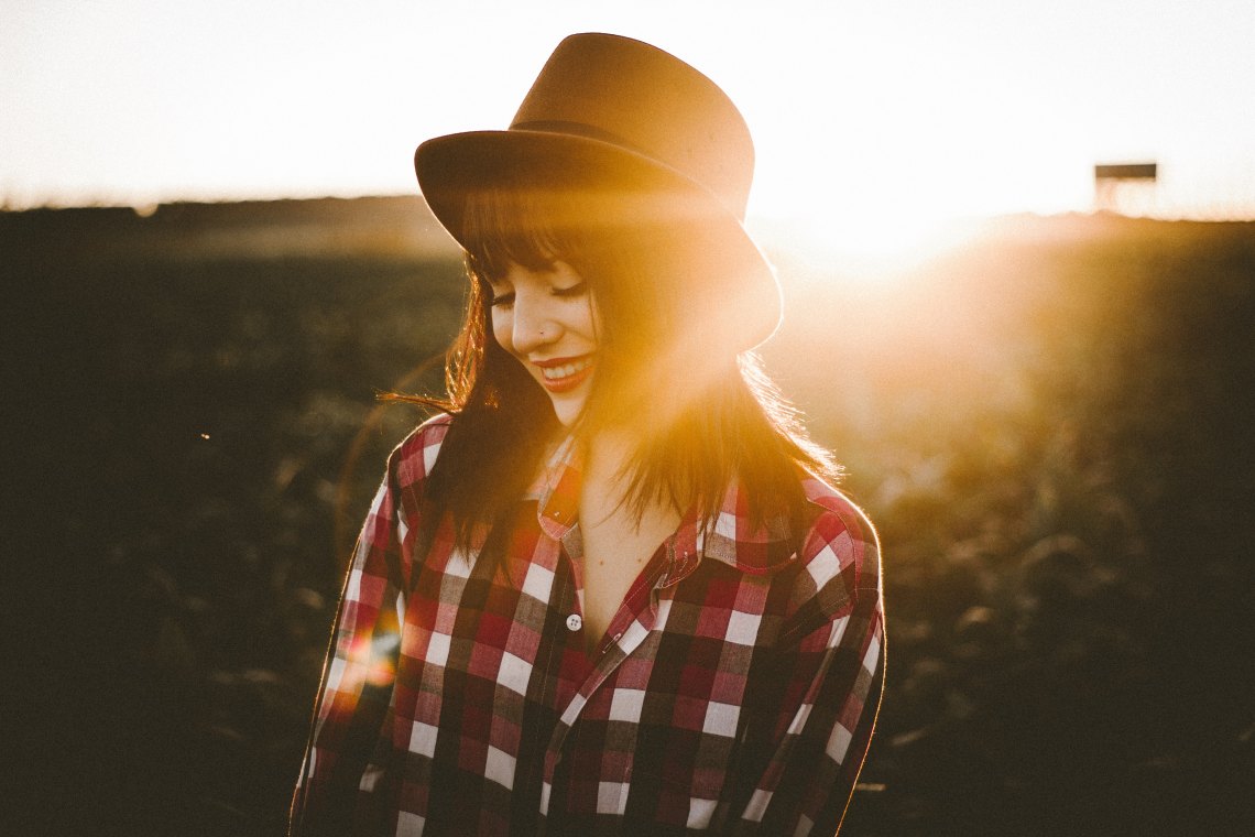 Woman wearing fedora and plaid shirt