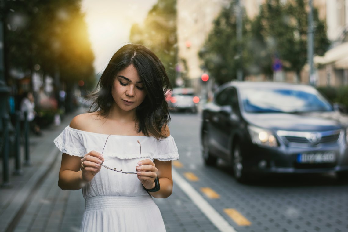Woman in white dress walking in city