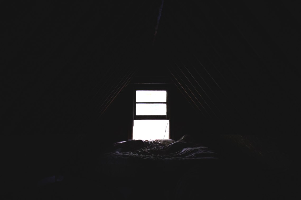 A dark room with a bed