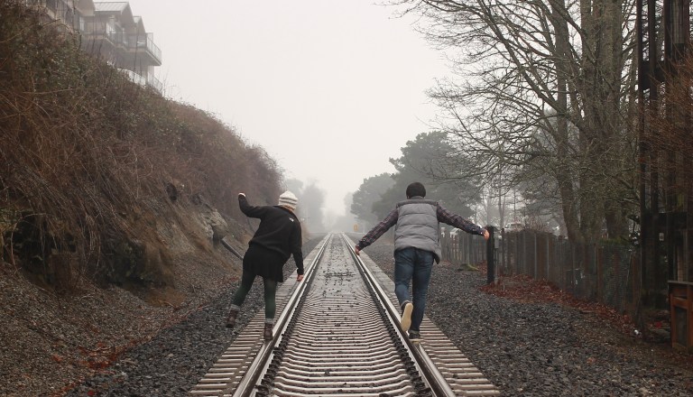 couple walking along train tracks, happy couple, can't fix you