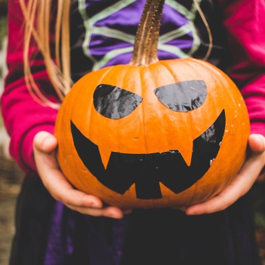 Girl holds a Jack-O-Latern in her hands for Halloween