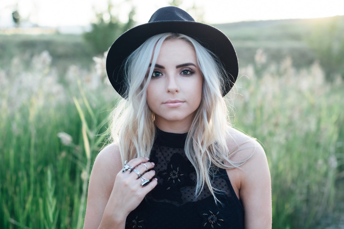 Woman in fedora in field