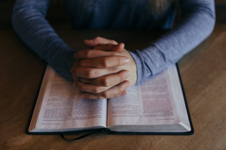 person praying over a bible
