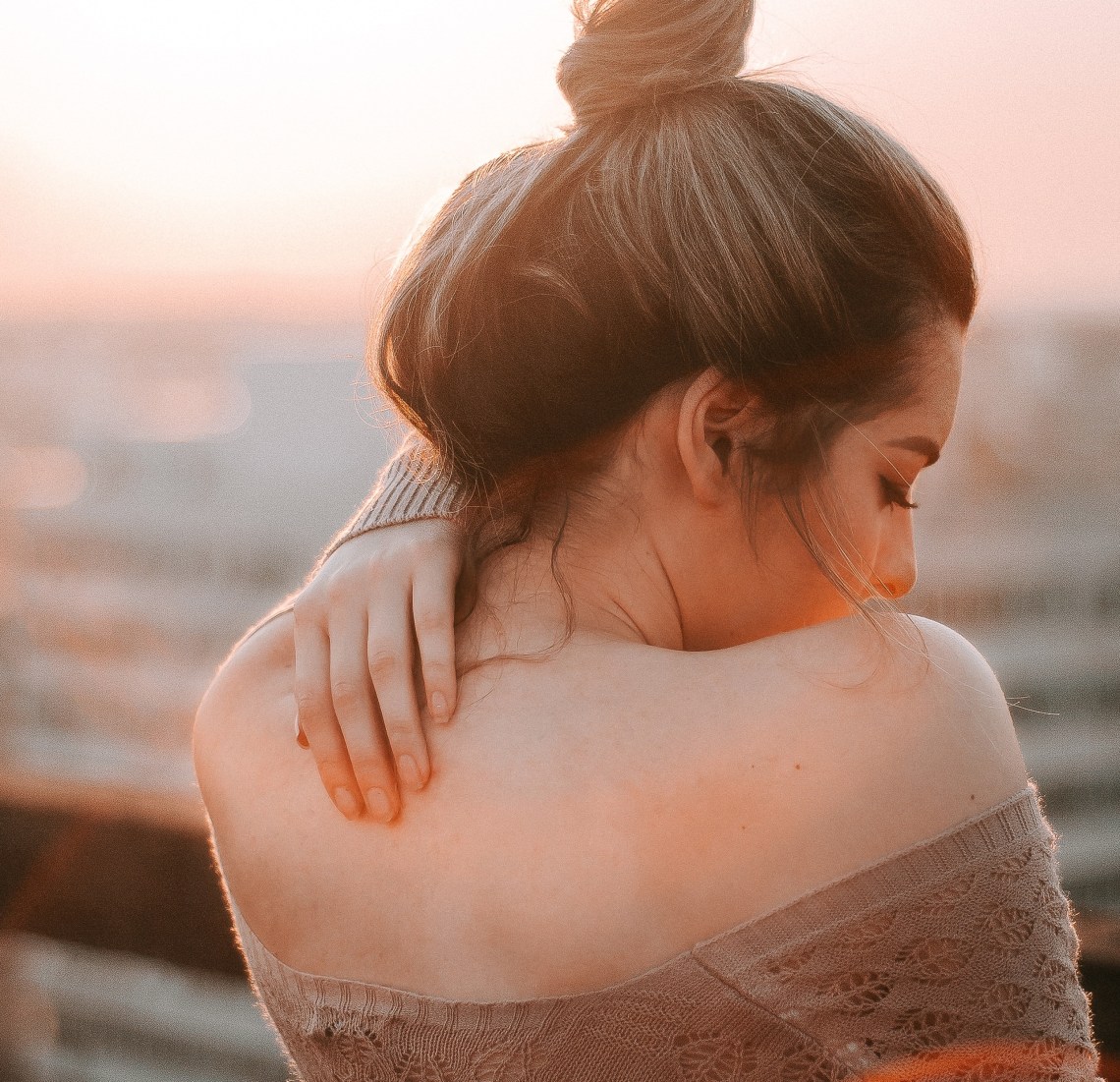 girl with hand on her back, girl in sunset, finding joy