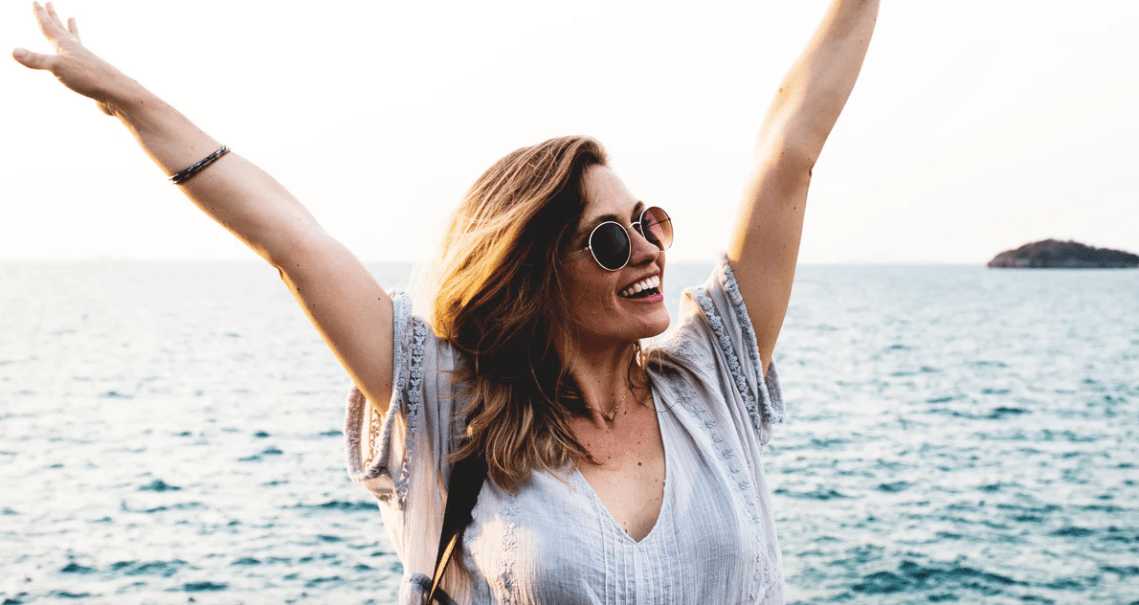 Woman laughing in front of ocean