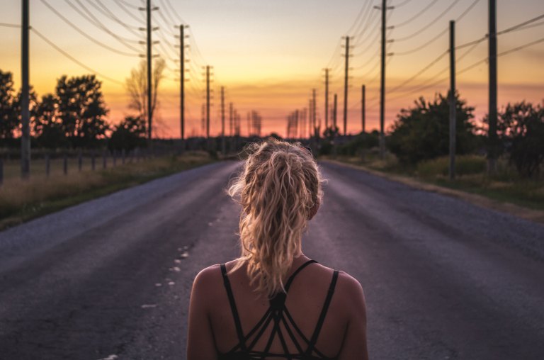 girl at a crossroads, girl looking at road, trusting the road ahead