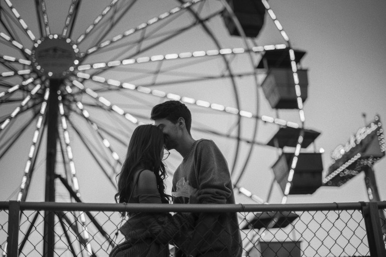 couple in front of a ferris wheel