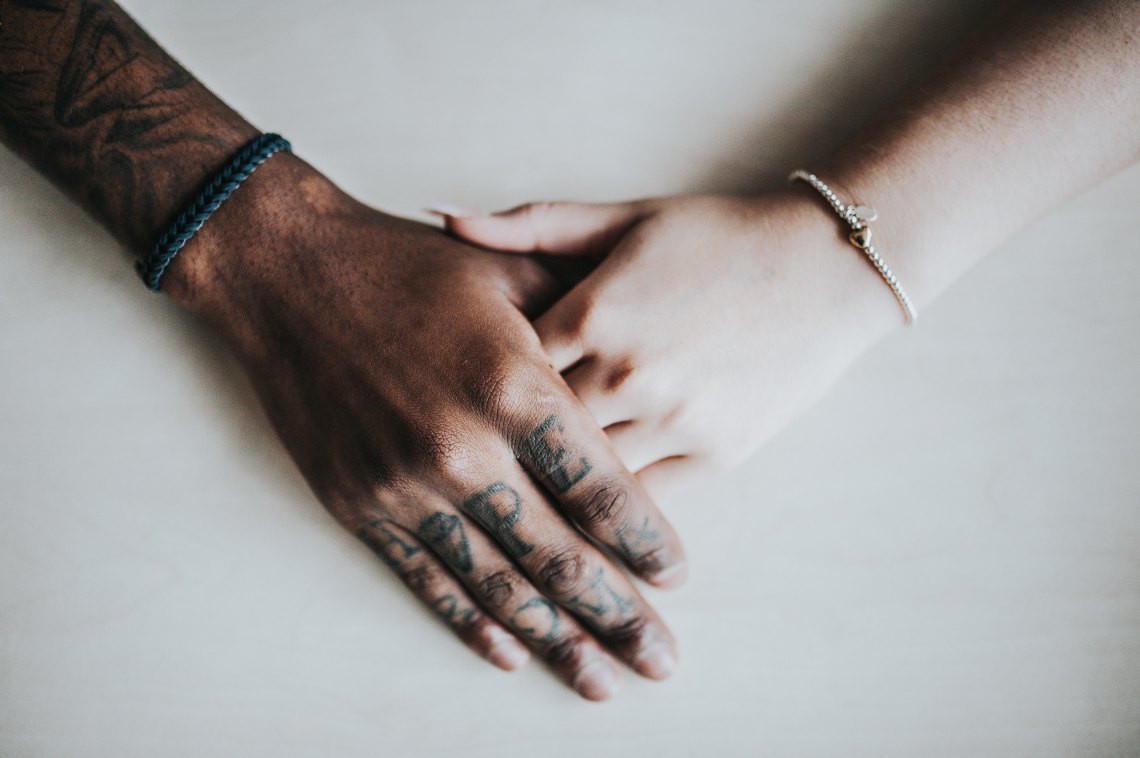 A black man and a white woman hold hands