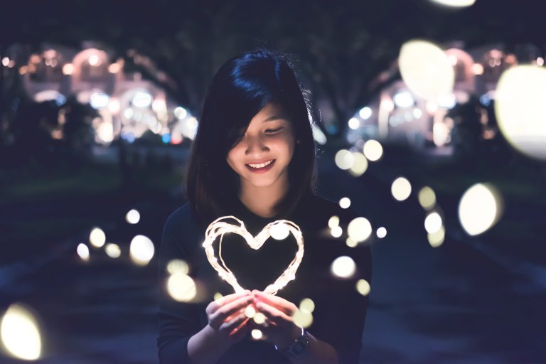 Woman holding heart-shape light
