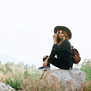girl in hat sitting in nature
