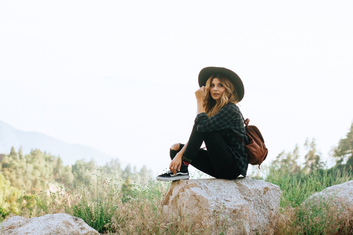 girl in hat sitting in nature