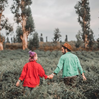 Couple holding hands in field