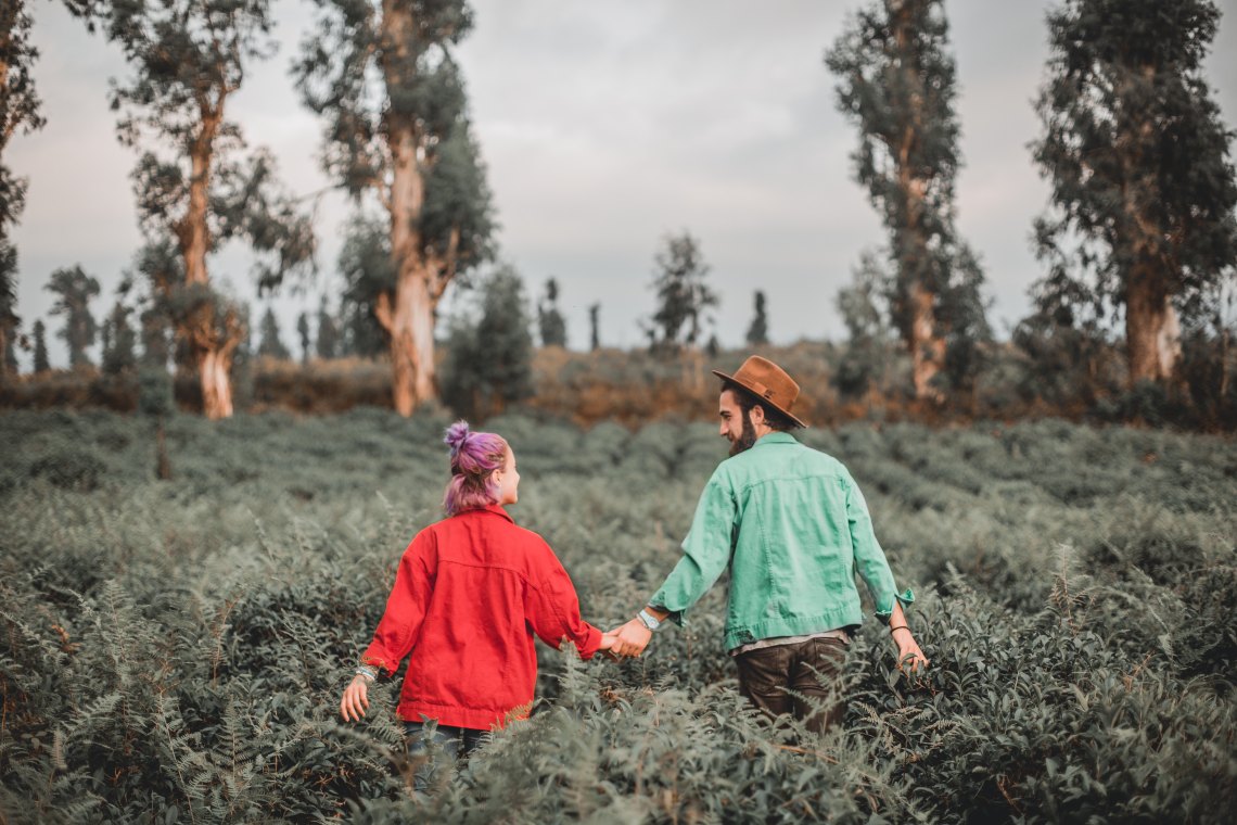 Couple holding hands in field