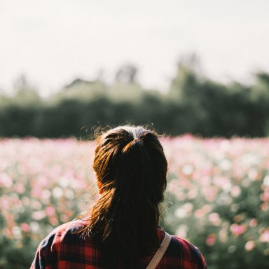 girl in a field hair smiling