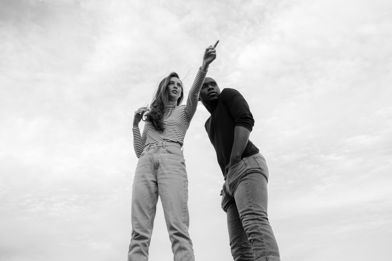 Relaxed Lovers Looking Beyond the Peak while She Points at Something