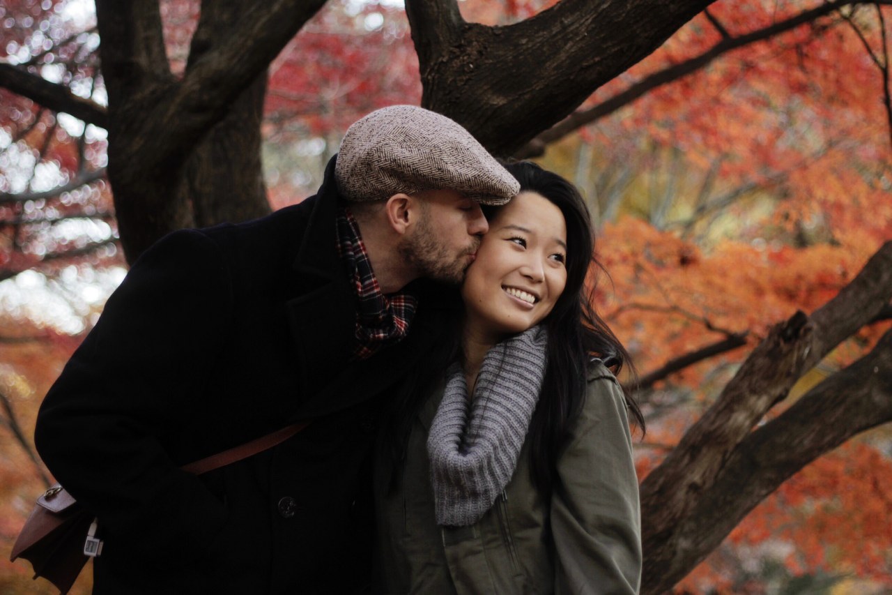 autumn couple kissing on the cheek