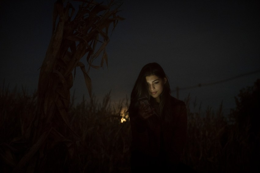 girl standing in the dark backlit by the moon