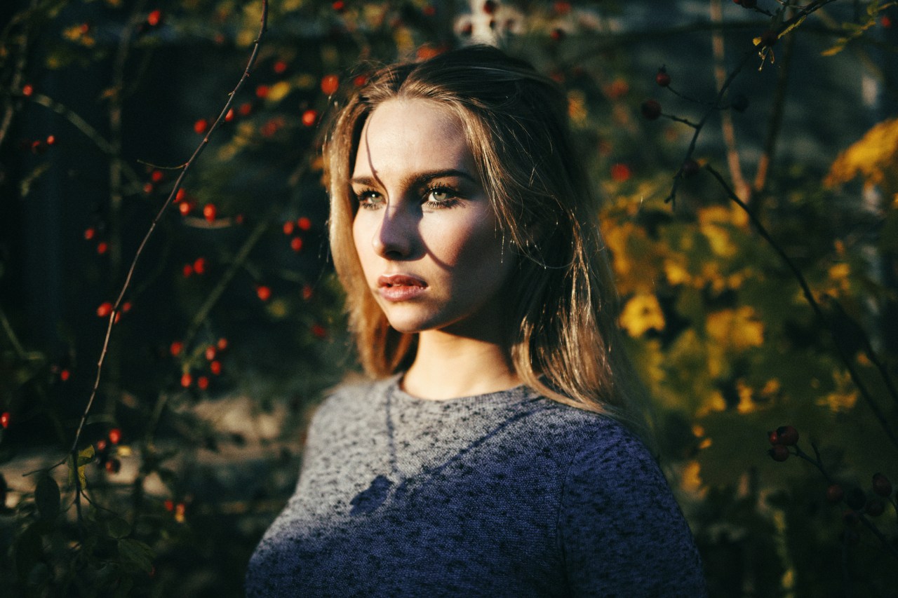 girl thinks by red berries