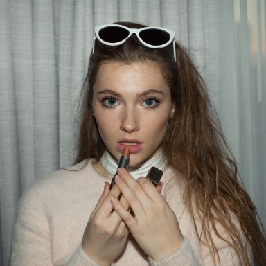 woman putting on lipstick